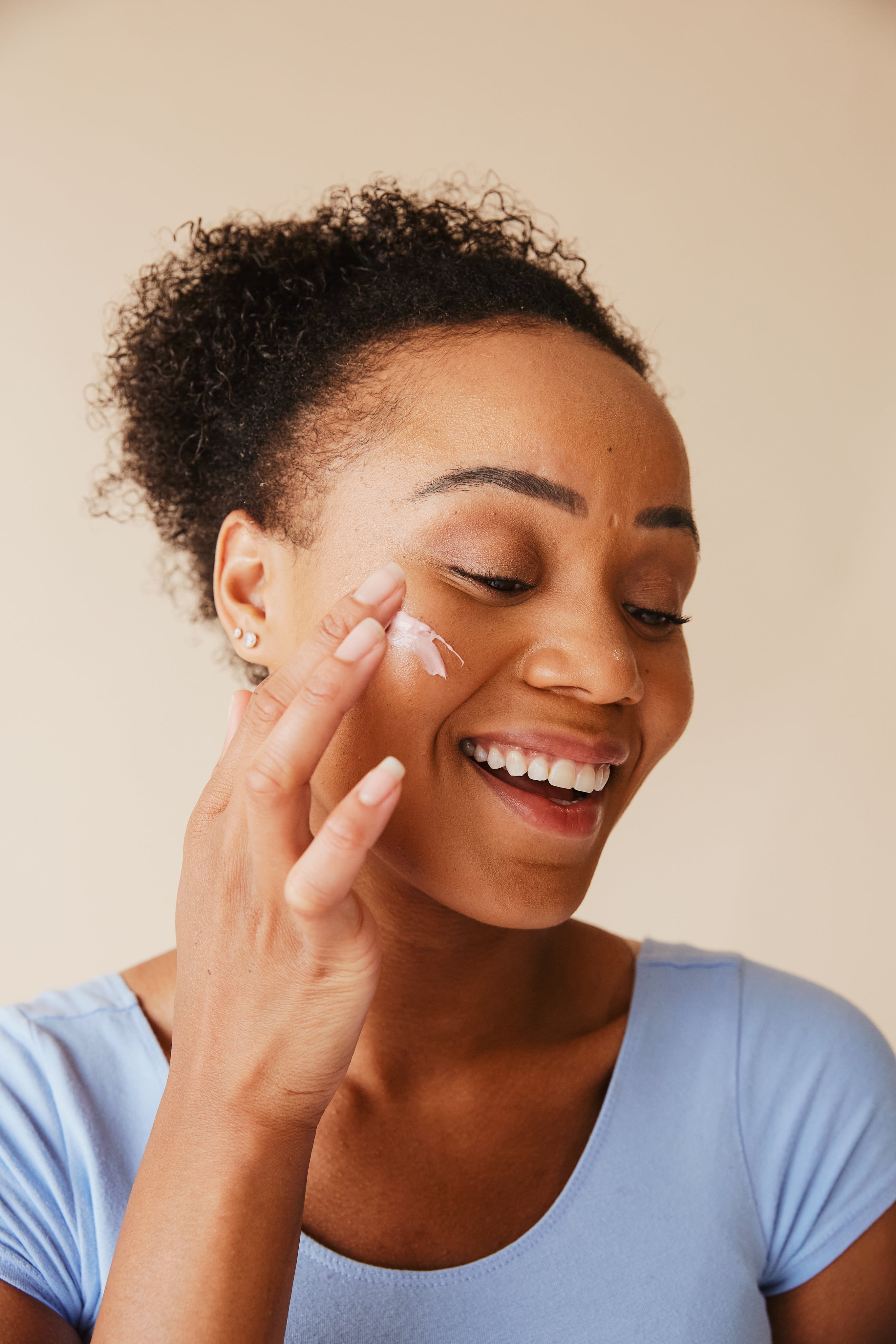 Mature woman smiling while caring for her skin